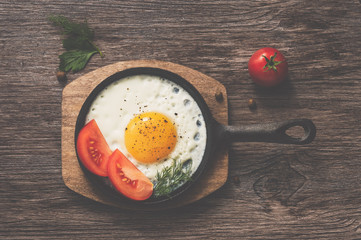 Scrambled eggs in a frying pan, in a rustic toning.