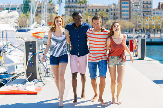 Group of friends enjoying a sunny day walking on the harbor.