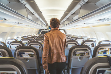 Woman walking down the aisle of an airplane