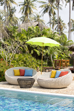 Swimming pool and rattan daybeds in a tropical garden, Thailand