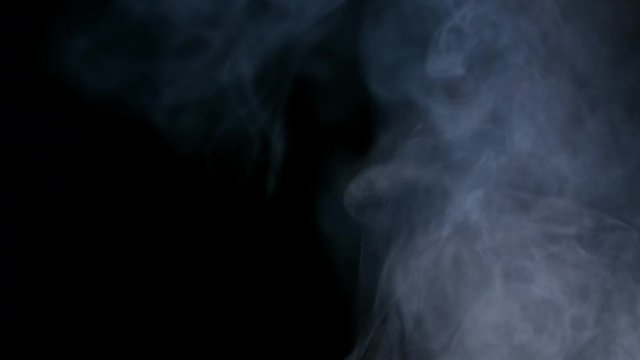 Smoky fog clouds over a black background. You can add this footage to your video project by dropping it in and changing its blending mode to Screen or Add