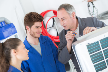 Obraz premium teacher helping students training to be electricians
