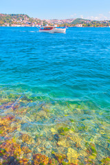 Luxury yacht crosses Bosphorus between European and Asian sides in Istanbul - Crystal clear sea water