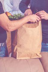 man holds paper bags with food in hands