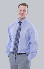 Young manager in suit is smiling isolated on gray background