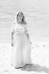 A middle-aged woman, plus in a light blue dress, rests on a city waterfront on a day off. The concept of femininity and romance in the city bustle