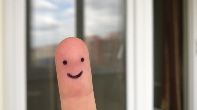 Funny finger people smiling window Happy finger art smiley face at blurred outdoor background