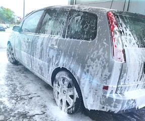 mycie auta na myjni samoobsługowej bezdotykowej, samochód pokryty pianą, widok na samochód z boku, 
