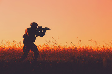 military soldier with weapons at sunset. shot, holding gun, colorful sky. military concept.