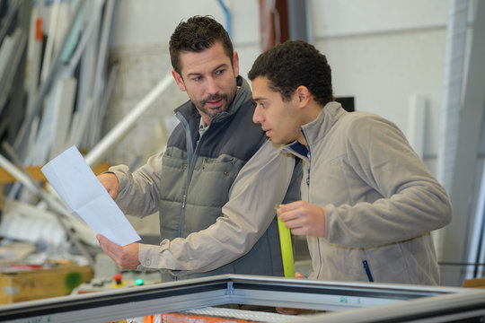 businessman and worker checking inventory in a large warehouse