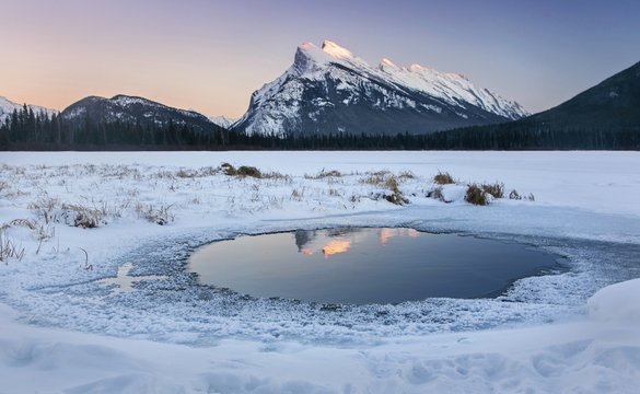 Snowy Distant Mountain Rundle Top reflected in Vermillion Lakes Landscape during cold winter in Banff National Park, Rocky Mountains Alberta Canada