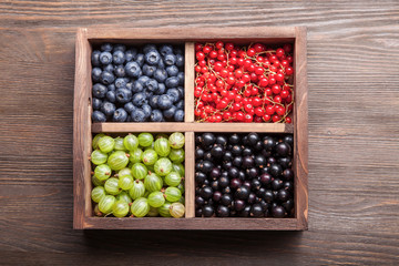 Red black currant blueberry gooseberry in a wooden box