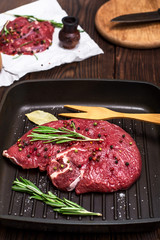 raw beef steak on a black frying pan
