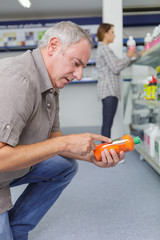 Senior man reading the label on a product