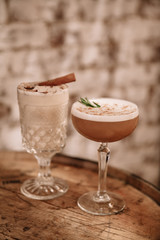 Two creamy alcoholic cocktails against white brick background