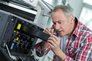 senior man and technician repairing a large copier toner