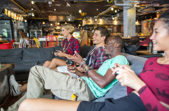 Group Of Friends Playing Video Games And Having Fun Together