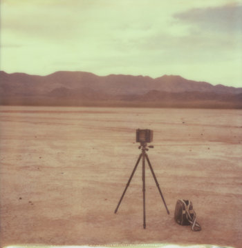 Large Format Camera on a Tripod with a Bag Sitting in the Middle of the Desert