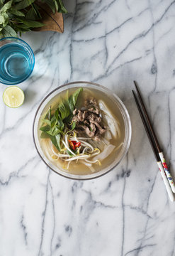 A bowl of beef pho on marble background