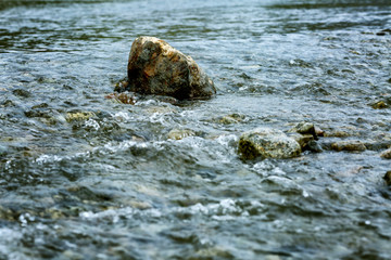 A large stone in the stream of a mountain river