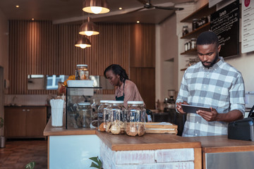 Two African entrepreneurs busy working at their cafe counter