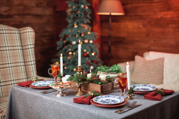 Beautiful Christmas family dinner table at the nicely decorated New Year interior with Christmas tree
