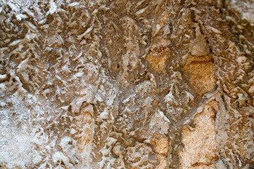 Wall - Sandstone surface background. Sandy wall with dirt. Dirty dark patches of clay.