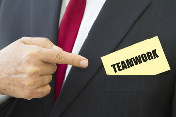 Businessman showing a card with text TEAMWORK