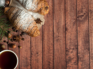 Christmas Breakfast croissant on a napkin. Dark wooden background. Christmas decorations Copy space