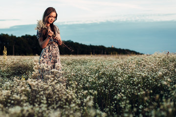 beautiful girl in the evening blooming field