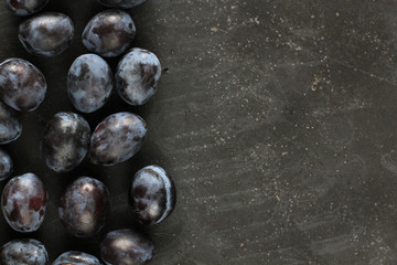Plums on black board.