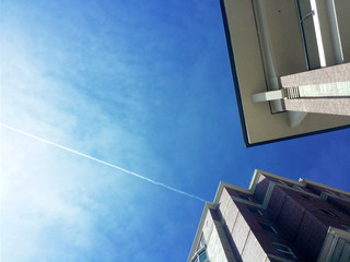 Naklejka premium Airplanes flying over the city's interesting architectural angles