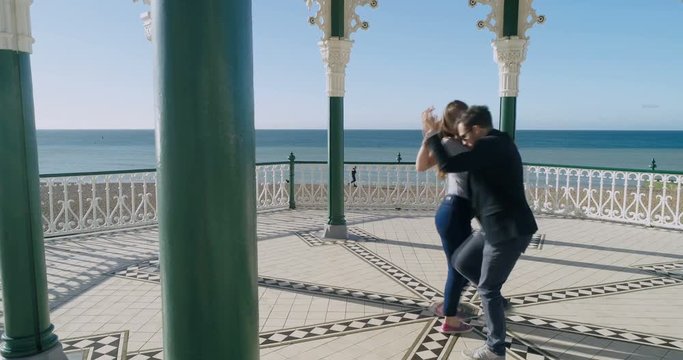 Aerial view of Caucasian young couple dancing salsa in the Victorian bandstand in Brighton