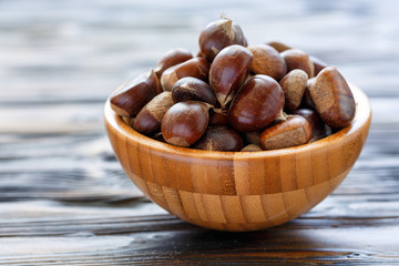 Fresh chestnuts in a wooden bowl.