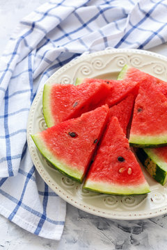Juicy watermelon sliced on a white porcelain dish.