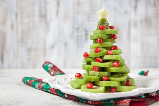 Healthy dessert idea for kids party - funny edible kiwi pomegranate Christmas tree