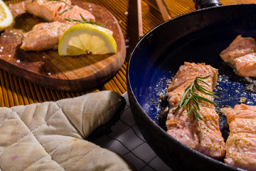 Salmon fillets. Grilled salmon, rosemary - herb decorationon on vintage pan or wooden board. roasted fish , wooden table. Studio shot.