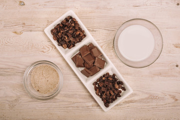 Chocolate bar and dried grapes in white bowl