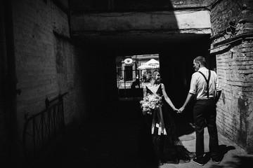 Wonderful bride and groom in the small street at sunny day