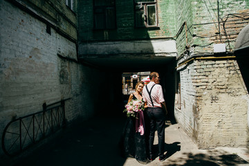 Fototapeta na wymiar Wonderful bride and groom in the small street at sunny day