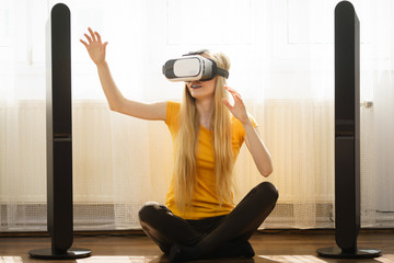 Girl wearing virtual reality goggles at home