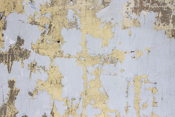 Ragged textured paint cover on a crumbling of the old stucco wall