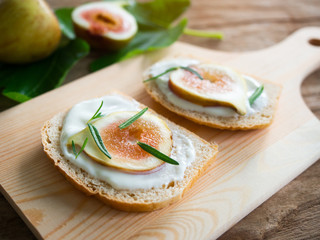 Fresh figs sliced and yogurt on bread for healthy breakfast.