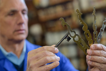 senior professional with different types of keys in locksmith