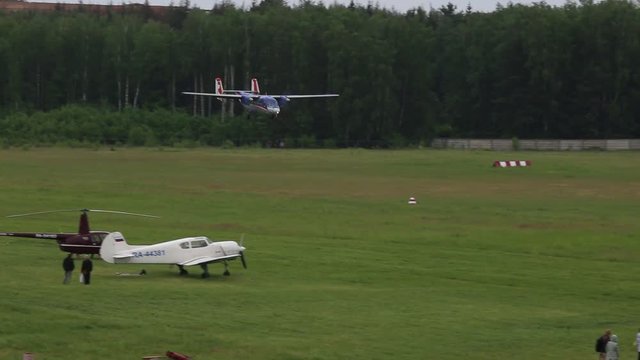 The plane lands on a green lawn.