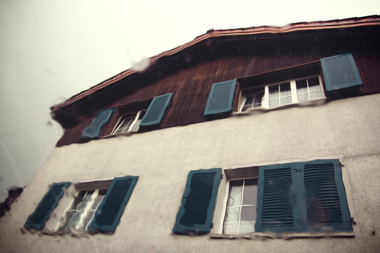 House facade through a wet windshield