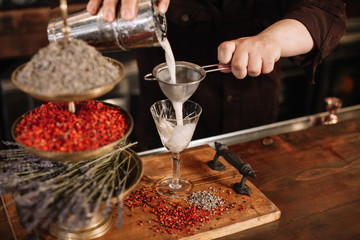 Bartender pouring a cocktail at a bar