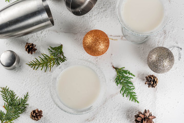 Ideas and recipes for Christmas drink. White Chocolate Snowflake Martini cocktail, on white marble table with Christmas decoration, copy space top view