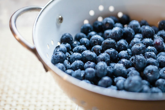 Close up of a colander full of freshly washed blueberries