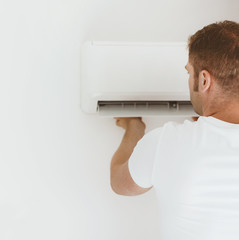 Male technician installing air-conditioning system.